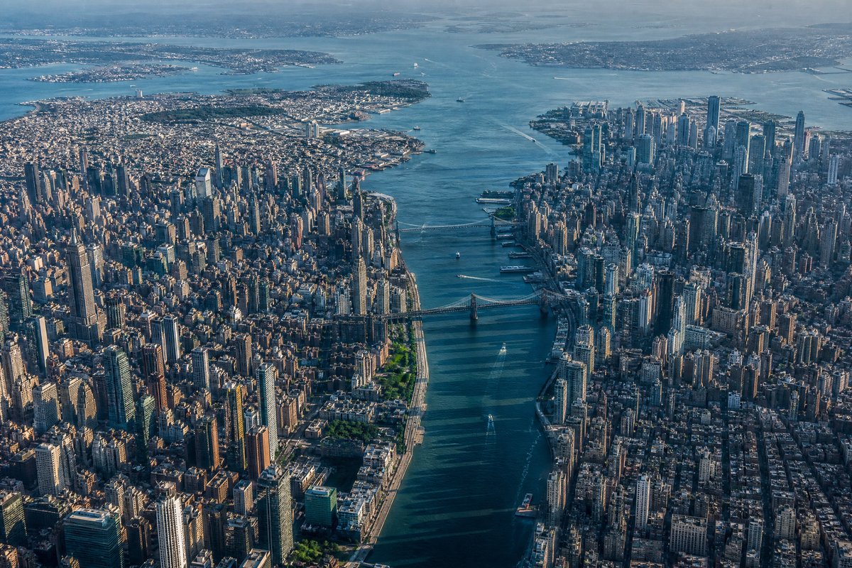 Aerial view of two dense cities separated by a narrow waterway